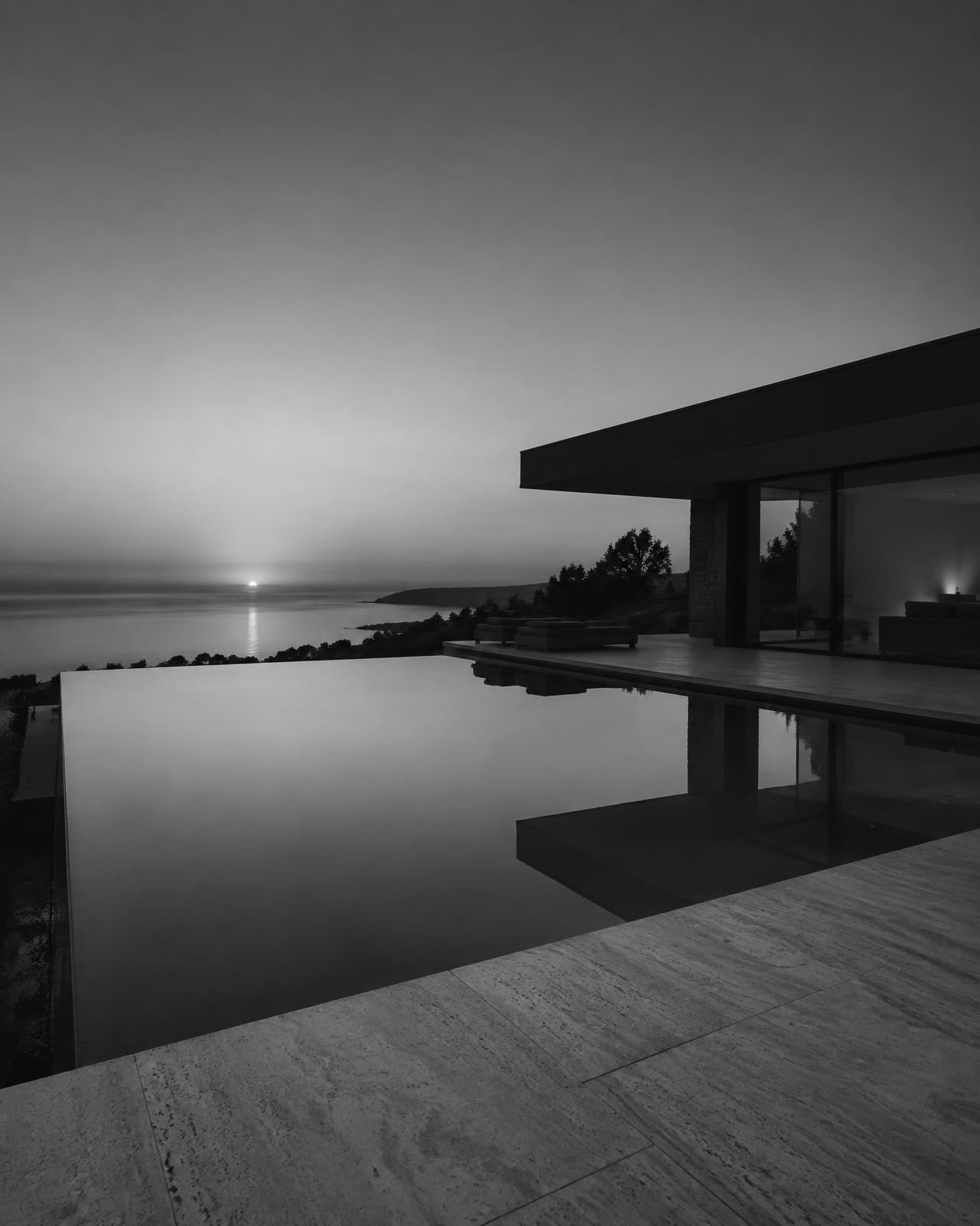 Vanishing-edge pool at dusk with travertine terrace